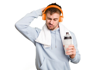 Young caucasian sporty man ready to start his gym day touching back of head, thinking and making a choice.