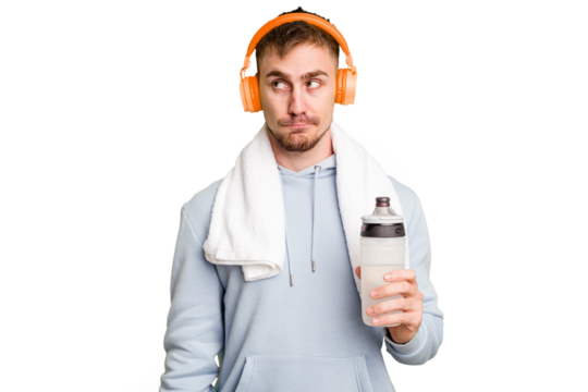 Young caucasian sporty man ready to start his gym day confused, feels doubtful and unsure.