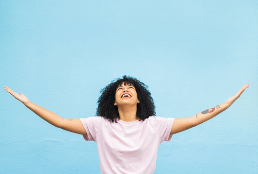 Black woman, happy and open arms in studio for marketing mockup, happiness celebration and excited in blue background. African girl, smile and surprised hands gesture or surprise growth development