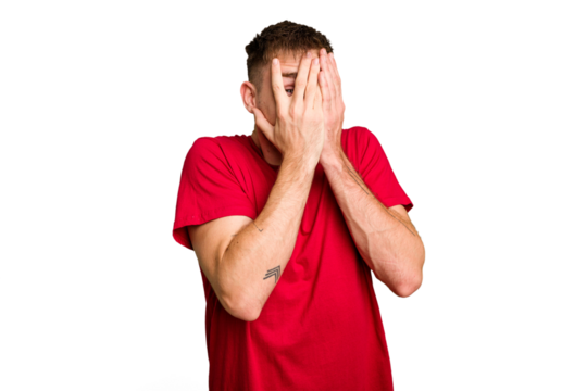 Young caucasian man cut out isolated blink through fingers frightened and nervous.