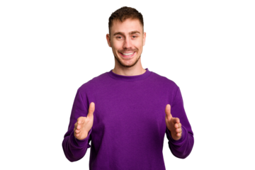 Young caucasian man cut out isolated holding something with both hands, product presentation.