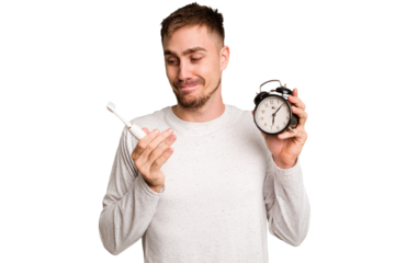 Young man holding an electric brush and an alarm clock cut out isolated