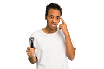 Young African American man holding a razor isolated showing a disappointment gesture with forefinger.
