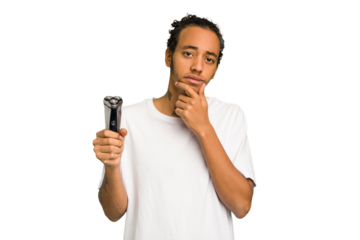 Young African American man holding a razor isolated looking sideways with doubtful and skeptical expression.