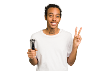 Young African American man holding a razor isolated joyful and carefree showing a peace symbol with fingers.