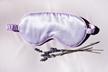 Sleep mask with natural lavender on the bed. Side view, space for text. Healthy sleep concept.
