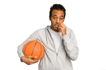 Young african american man playing basketball isolated biting fingernails, nervous and very anxious.