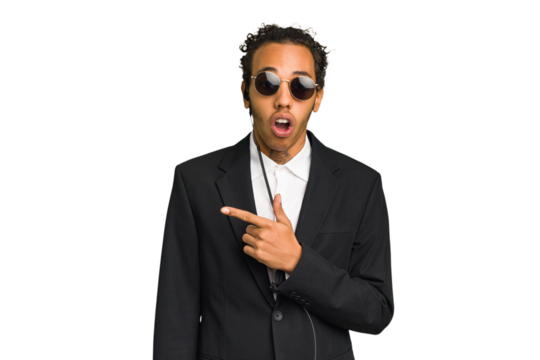 Young African American bodyguard man isolated pointing to the side