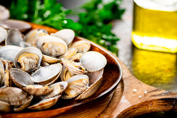 Fototapeta premium Vongole on a wooden plate with parsley. 
