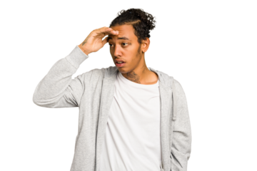 Young African American man isolated looking far away keeping hand on forehead.