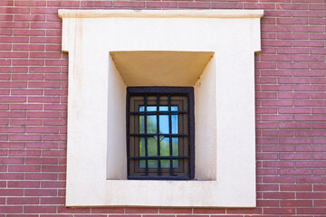 Obraz premium A window with rusty bars on it in an old brick building, close-up.