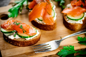 Salmon sandwich on a wooden cutting board. 