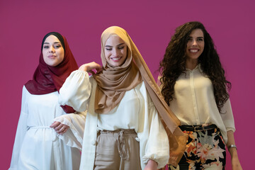 Group portrait of beautiful muslim women two of them in fashionable dress with hijab isolated on...