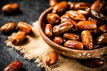 Full wooden plate with dates on the table. 
