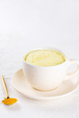 Indian turmeric latte from almond milk, ginger, turmeric and cinnamon in a mug, sugar and lactose free.