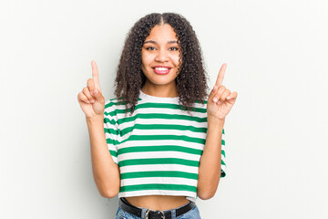Young african american woman isolated on white background indicates with both fore fingers up...