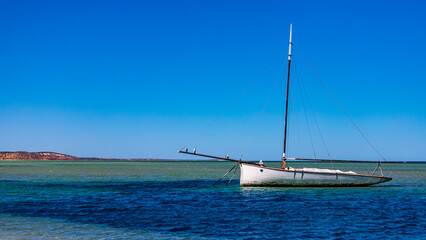 beautiful old yacht standing on the denham marina in shark bay near francois peron national park; australian outback, turquoise ocean
