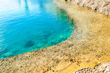 Sea lagoon with clear water. Shore is made of decorative stone.