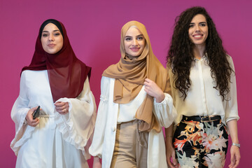 Group portrait of beautiful muslim women two of them in fashionable dress with hijab isolated on...