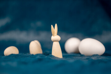 petit lapin de Pâques en bois avec des oeufs de différentes tailles