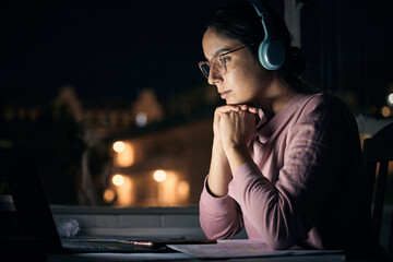 Laptop, night and music with a student woman in her home for learning, education or development...