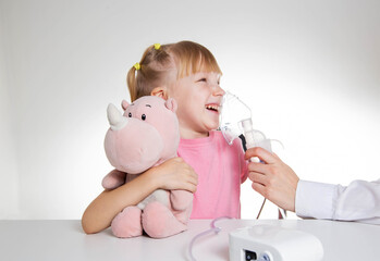 A 5-year-old girl breathes into an inhaler to dilute sputum in case of lung diseases. Treatment of...
