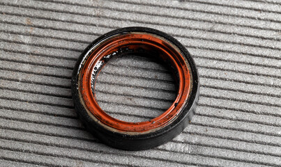 Camshaft oil seal in a car engine on a gray background, macro