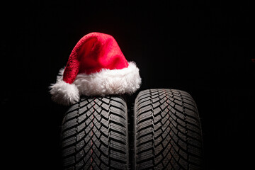 Car tire service and christmas hat on black background with copy space for text - 563904248