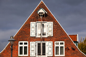 The upper part of a brick old German private house with casement windows.