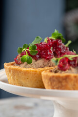 Tartlets stuffed with codfish liver, codfish caviar and microgreens. Traditional cold portioned appetizer in a pastry basket.