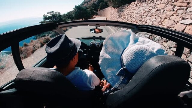 Couple Driving Convertible Car on Mountain Road in Santorini island at Ancient Thera, Greece