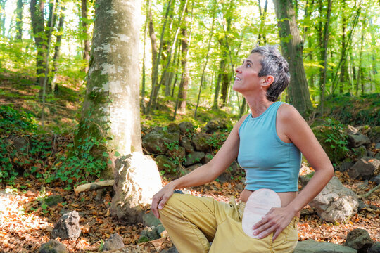 ostomized woman with a bag in her belly in the forest. courage and strength of survivor