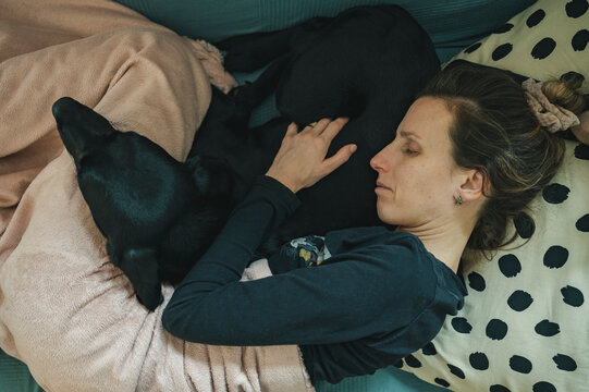 Young woman with a flu resting on a sofa with her dog