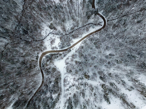 Top view of a road going through a snow covered winter nature