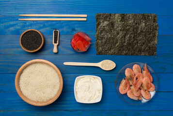 Fototapeta na wymiar Ingredients for sushi and rolls on wooden background, top view