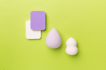 Beauty blenders on color background, top view