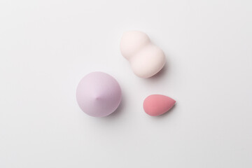Beauty blenders on color background, top view