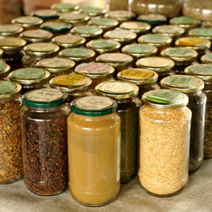Spices, cloves, cayenne, cumin, garlic ...(clavo, cayena, comino, ajo) in glass jars prepared for sale at a flea market