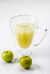 Indian gooseberry or amla fruit and juice having detox properties served in small glasses.