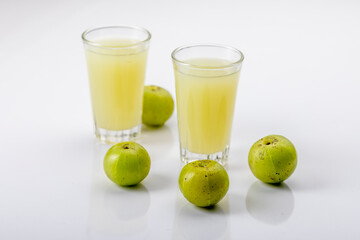 Fototapeta na wymiar Indian gooseberry or amla fruit and juice having detox properties served in small glasses.