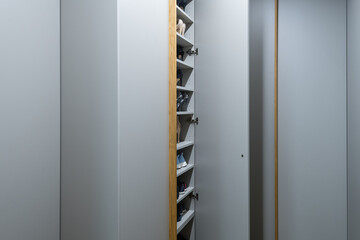 Giant gray closet full of shoes on hallway of modern apartment