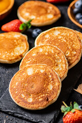 Naklejka na ściany i meble Pancakes on a stone board with fresh berries. 