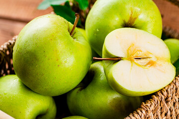 Ripe apples in a basket on the table. 