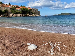 Palm tree on the sand made with rocks, copy space for text, perfect vacation postcard, tour agency...
