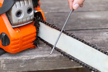 chainsaw chain sharpening with a special file. Dulling an old chain on a chainsaw bar. Industry