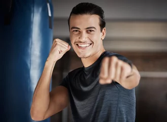 Zelfklevend Fotobehang Man, smile portrait and fist fight for fitness in gym for exercise workout, boxing training and sports wellness. Happy athlete, personal trainer and relax happiness for boxer cardio lifestyle in club © Jordan C/peopleimages.com