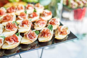 catering buffet table with snacks and appetizers. Set of canapés with jamon, bruschetta and cheese