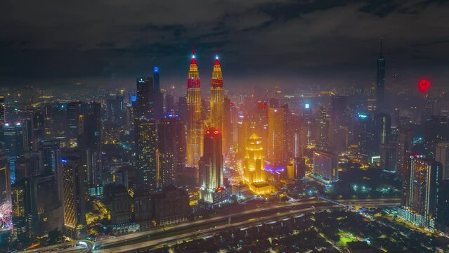 4K aerial hyperlapse of Kuala Lumpur cityscape during Chinese New Year Eve. KLCC and KL Tower lights up red and gold color. Year of the Rabbit