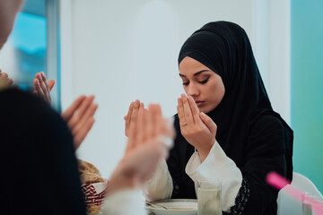 Muslim woman making iftar dua to break fasting during Ramadan.