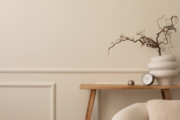 Minimalist composition of living room interior with copy space, wooden bench, white vase with branch, clock, silver ball, beige wall with stucco and personal accessories. Home decor. Template.